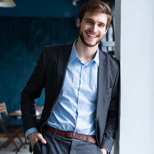 Business lifestyle. Confident professional handsome businessman standing near window in his office